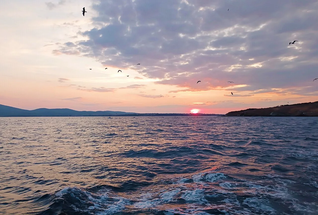 The sun setting over the sea near Sozopol, warm light spreading across the water toward the horizon