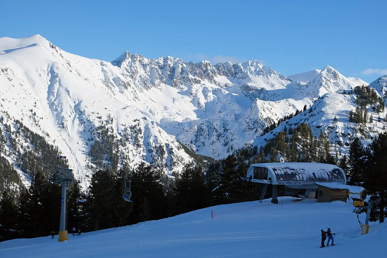 Beginners practising on a wide shallow slope at Bansko with instructors and rental gear visible