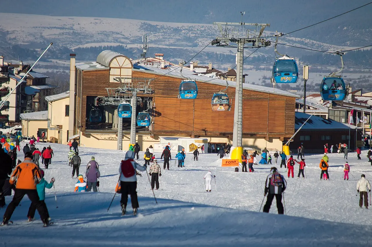 The Bansko gondola climbing through snowy forest toward the upper ski area where lessons meet