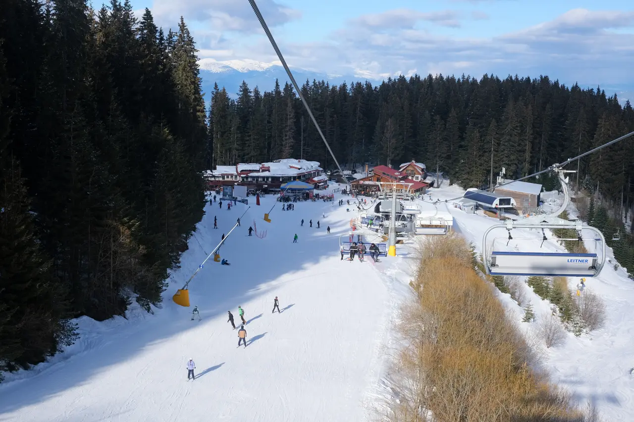 The Banderishka Polyana base area at Bansko with chairlifts, mountain restaurants and skiers on gentle terrain