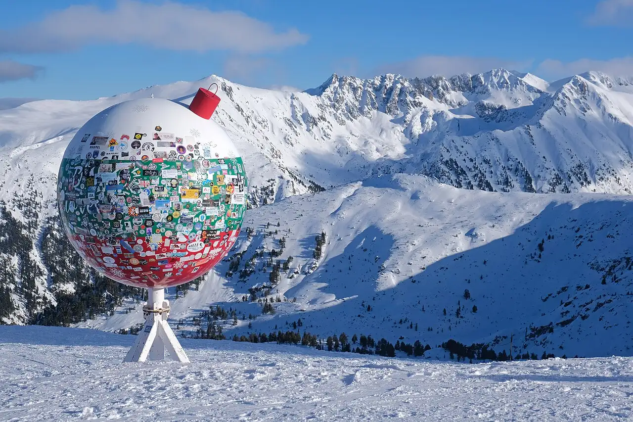 Groomed piste and lift pylons on the Bansko ski area with the Pirin ridge behind