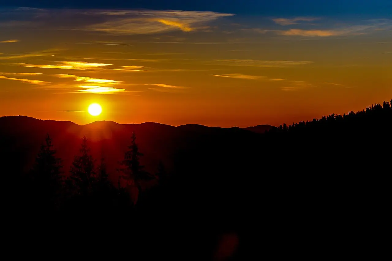 Sunset light over silhouetted Rhodope ridges and spruce forest near Pamporovo