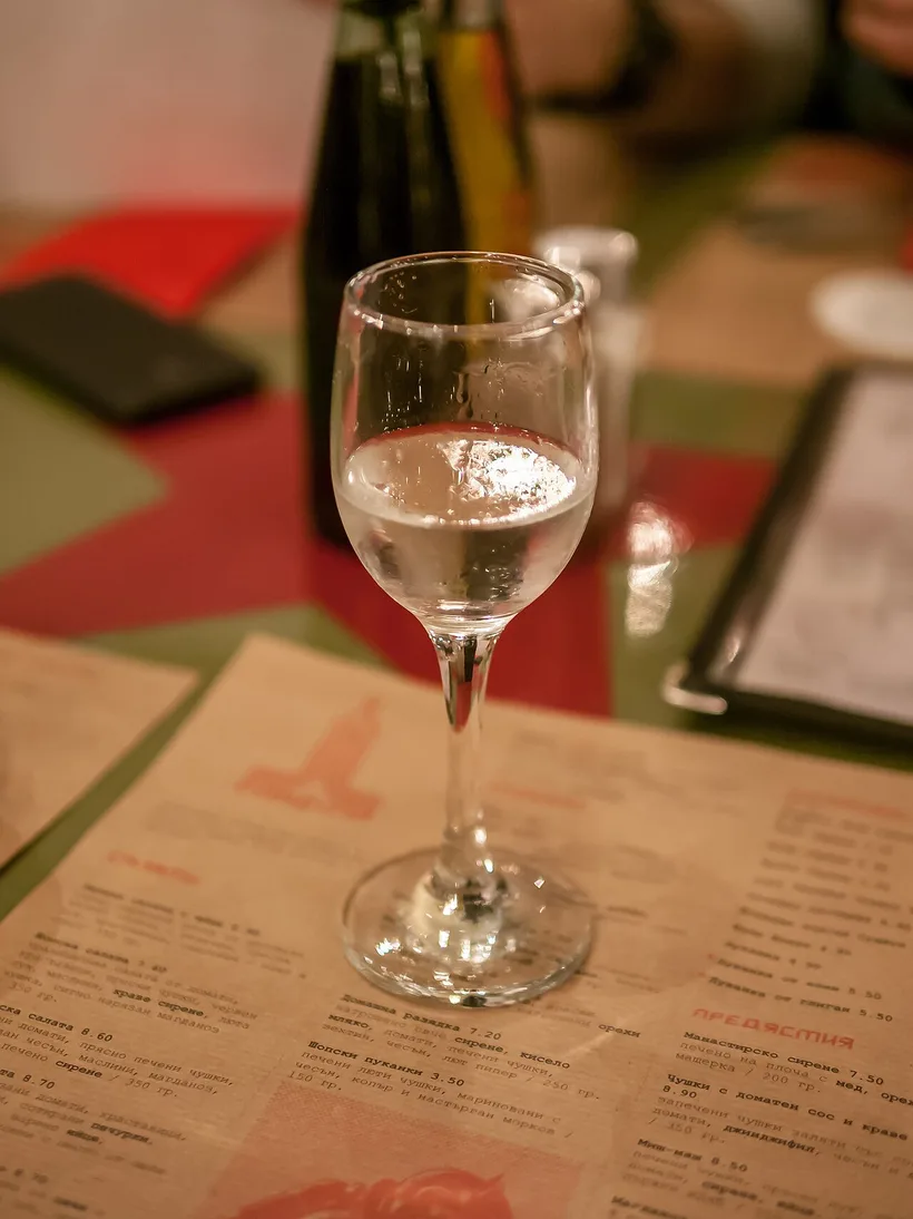 A small glass of clear rakia, the Bulgarian fruit brandy, on a table