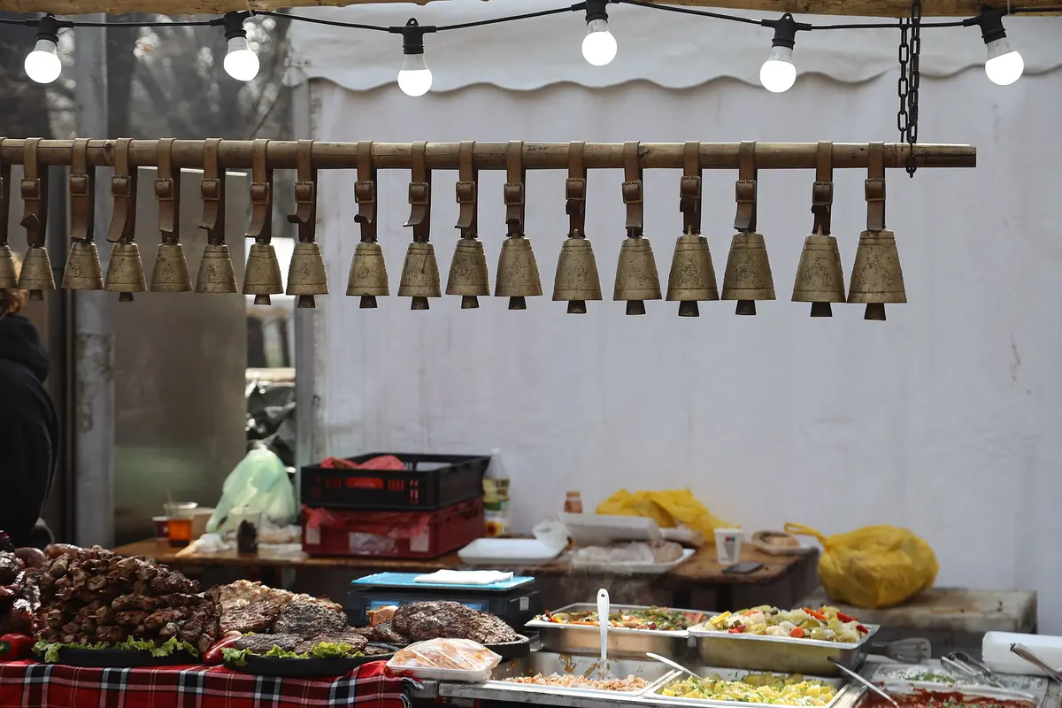 A spread of Bulgarian dishes including grilled meat, salad and bread on a wooden table