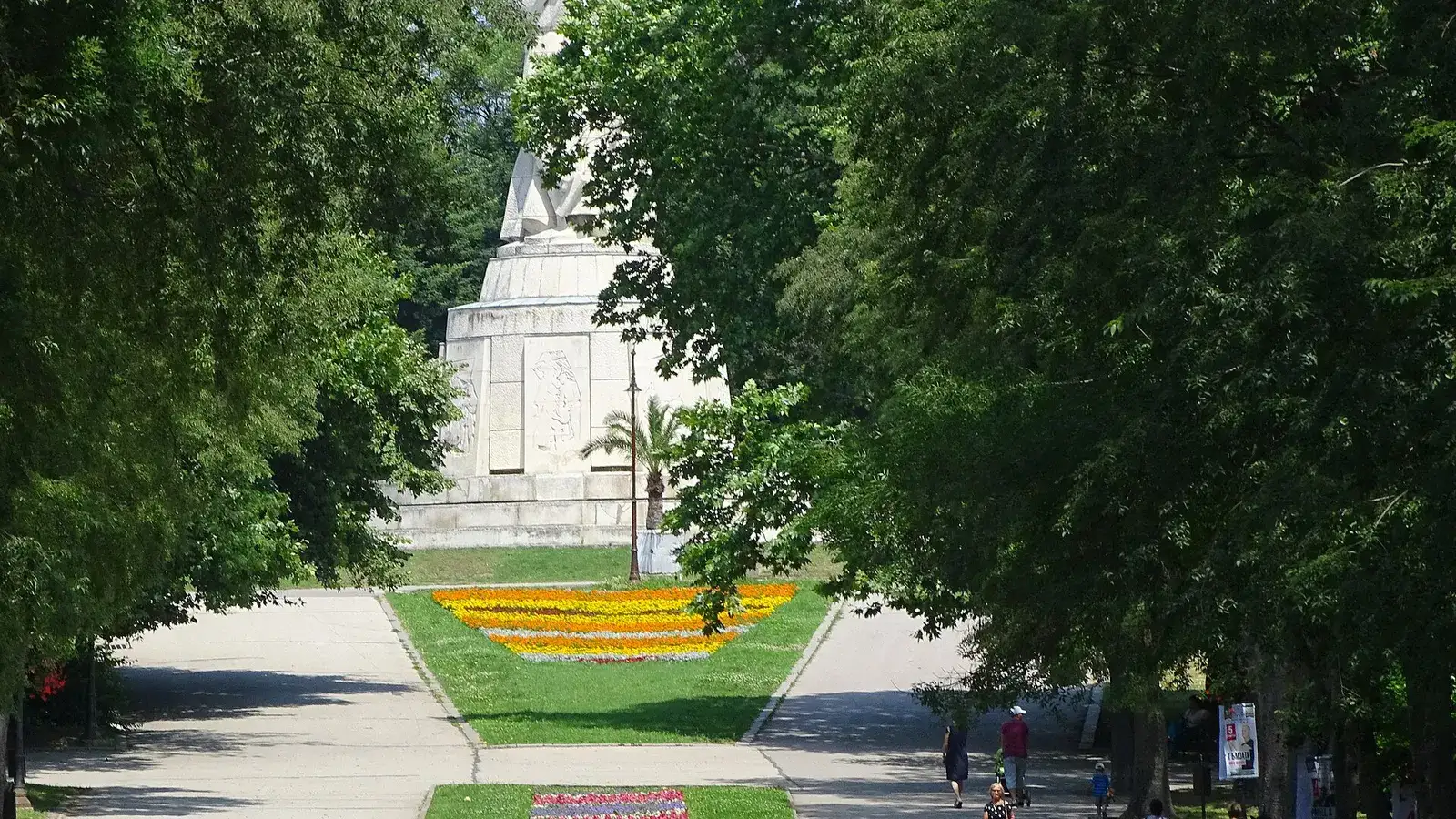 Tree-lined paths of Varna Sea Garden with the Black Sea and coastline visible beyond the park