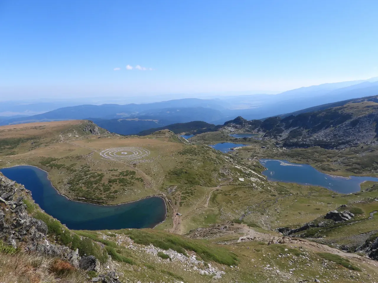 Aerial view of several of the Seven Rila Lakes in high summer with the white circle of the Paneurhythmy dance on the plateau