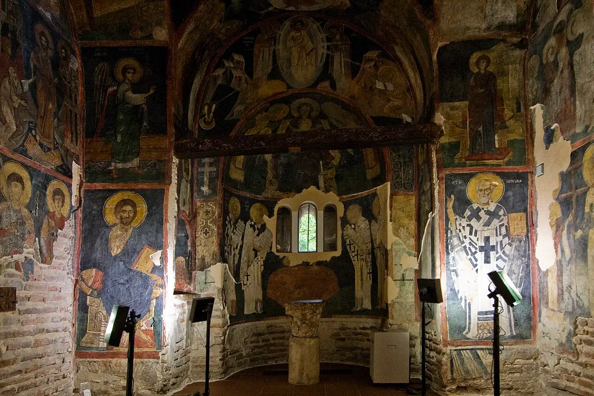 The eastern apse of Boyana Church with the altar and frescoed saints and a central window
