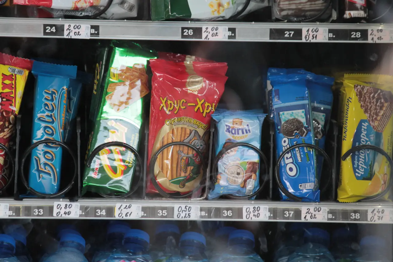 A Bulgarian vending machine with snacks, each slot showing two prices - the lev amount above and the euro amount below