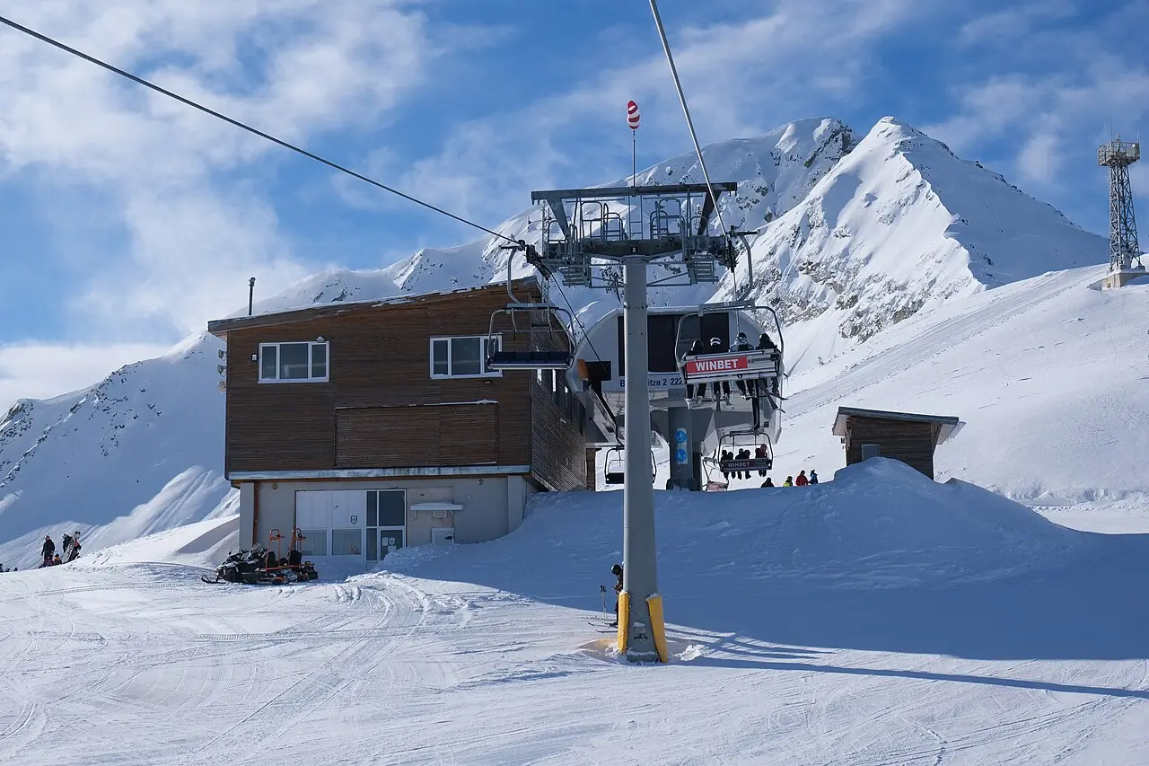 A wooden chairlift station high on the Bansko ski area with snow-covered ridgelines behind it