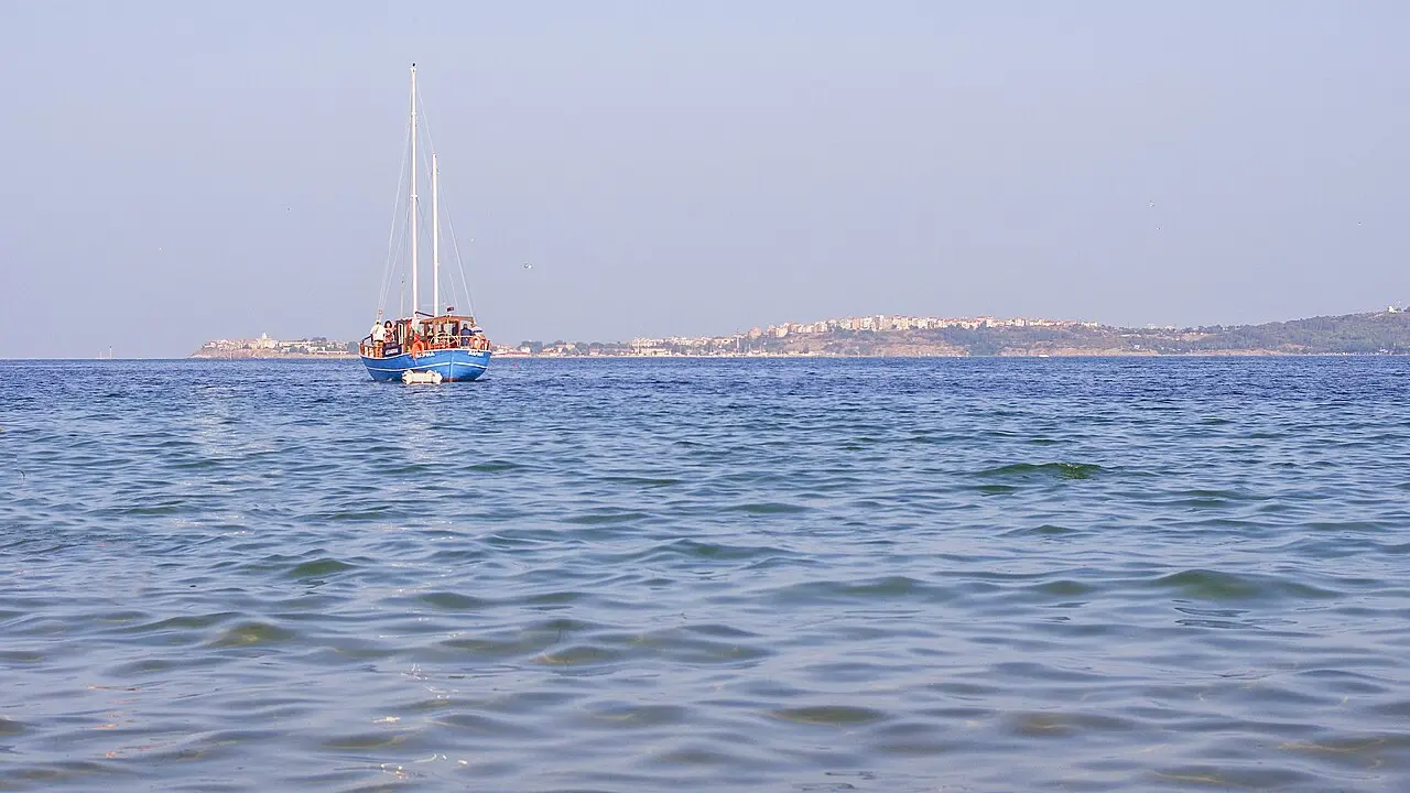 The old town of Sozopol on its rocky peninsula seen across the water from a sandy bay on the Bulgarian Black Sea coast