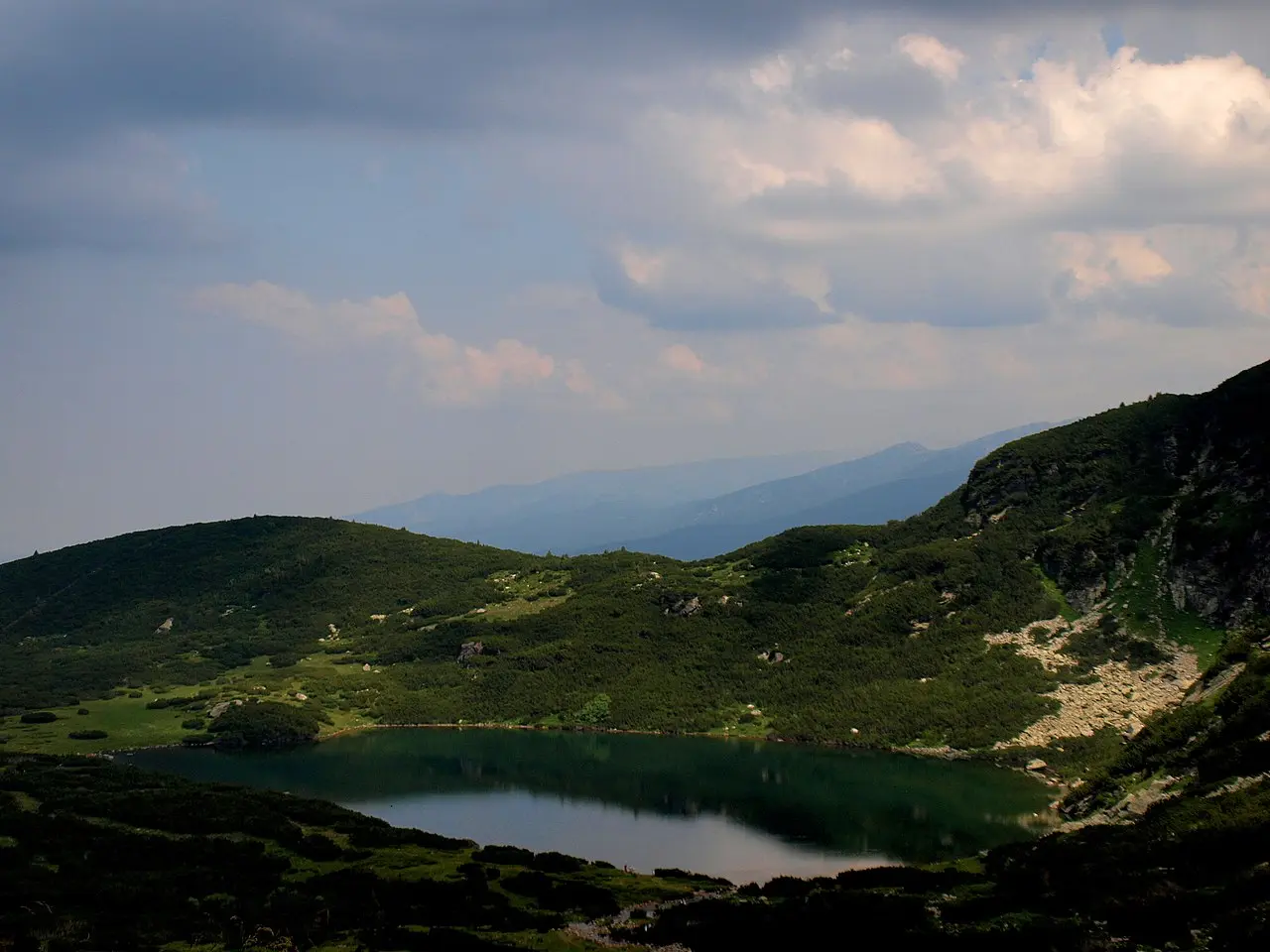 Two of the Seven Rila Lakes in a glacial cirque with hikers on the shore and peaks behind