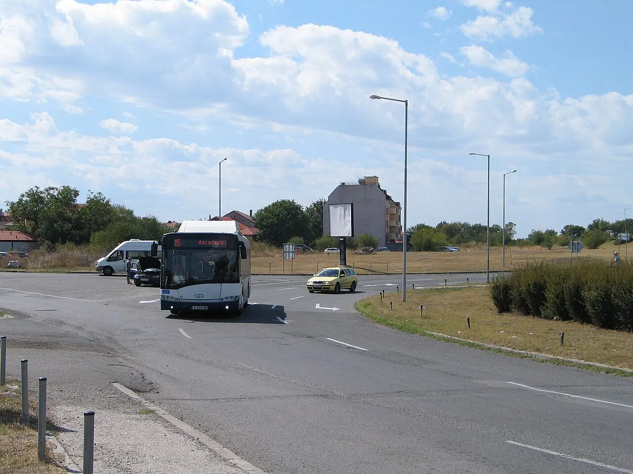 Bus number 15 signed for the bus station at the Sarafovo roundabout near Burgas Airport, with a yellow taxi alongside