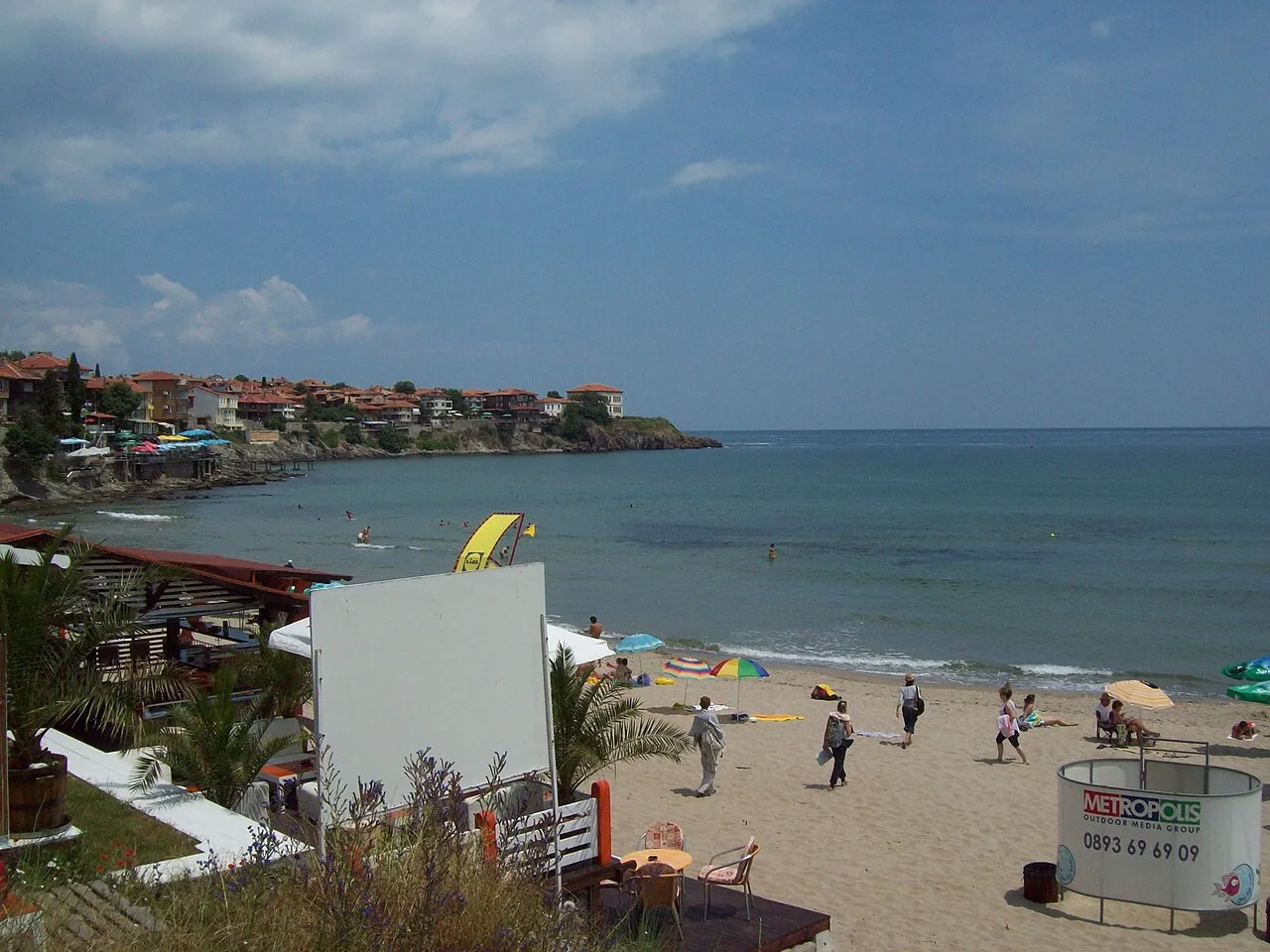 People on Sozopol beach with umbrellas and the Black Sea horizon
