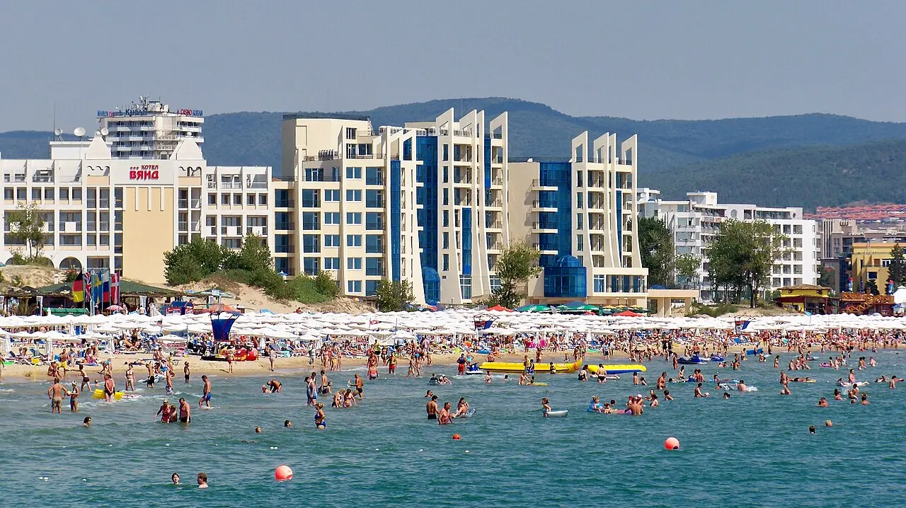 The busy beach and hotel strip of Sunny Beach on the Bulgarian Black Sea coast, with green hills behind