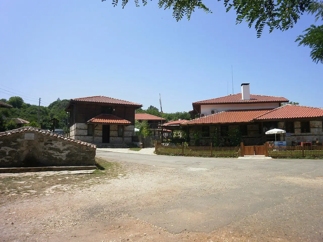 Timber Strandzha houses and stone walls along a quiet street in Brashlyan village