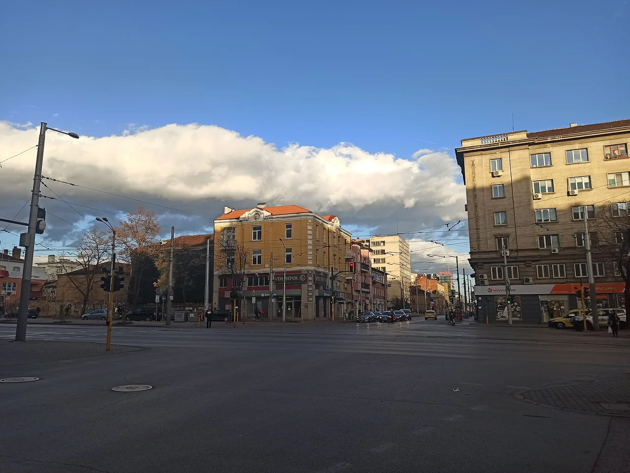 A busy junction in central Sofia with cars, tram lines and apartment blocks