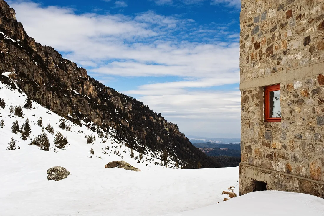 The rocky north face of Malyovitsa peak in the Rila mountains rising above a green alpine valley