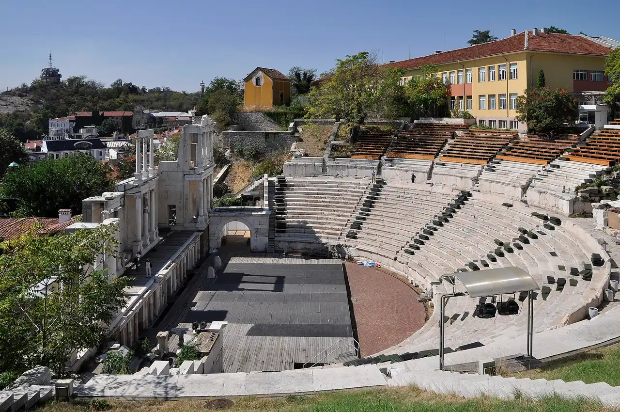 The marble tiers of the Roman theatre of Philippopolis in Plovdiv, looking across the stage to the old town houses and a hill beyond