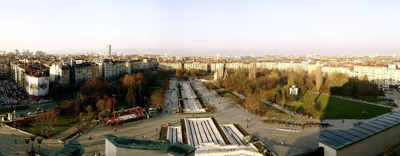 Panorama over central Sofia from the roof of the National Palace of Culture, the wide plaza and boulevards leading out to low apartment blocks with hills on the horizon