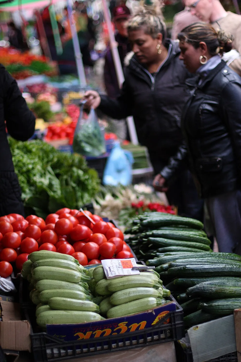 Open-air market stalls in Kazanlak stacked with fresh fruit and vegetables under sun umbrellas