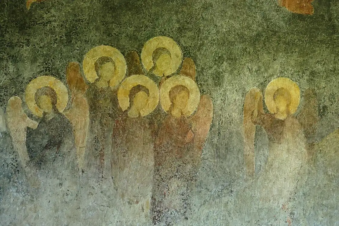 Faded medieval wall frescoes inside the Church of St Stephen in Nessebar showing a row of haloed angels in ochre and green