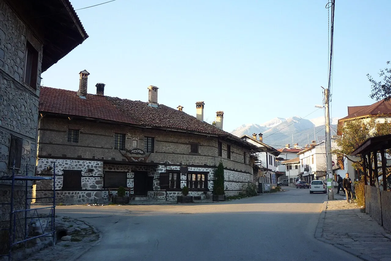 A stone-built old mehana in Bansko with the snow-topped Pirin mountains behind