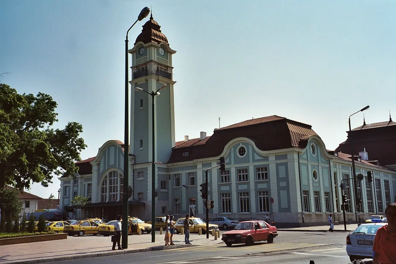 The street facade of Burgas railway station with parked cars and the station canopy