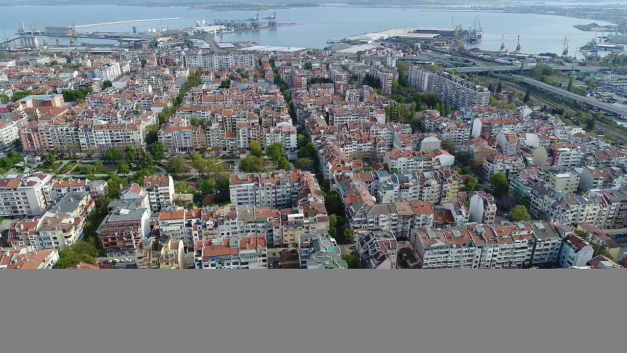 Aerial view over the Vazrazhdane quarter of Burgas, with apartment blocks, trees and the Black Sea plain beyond