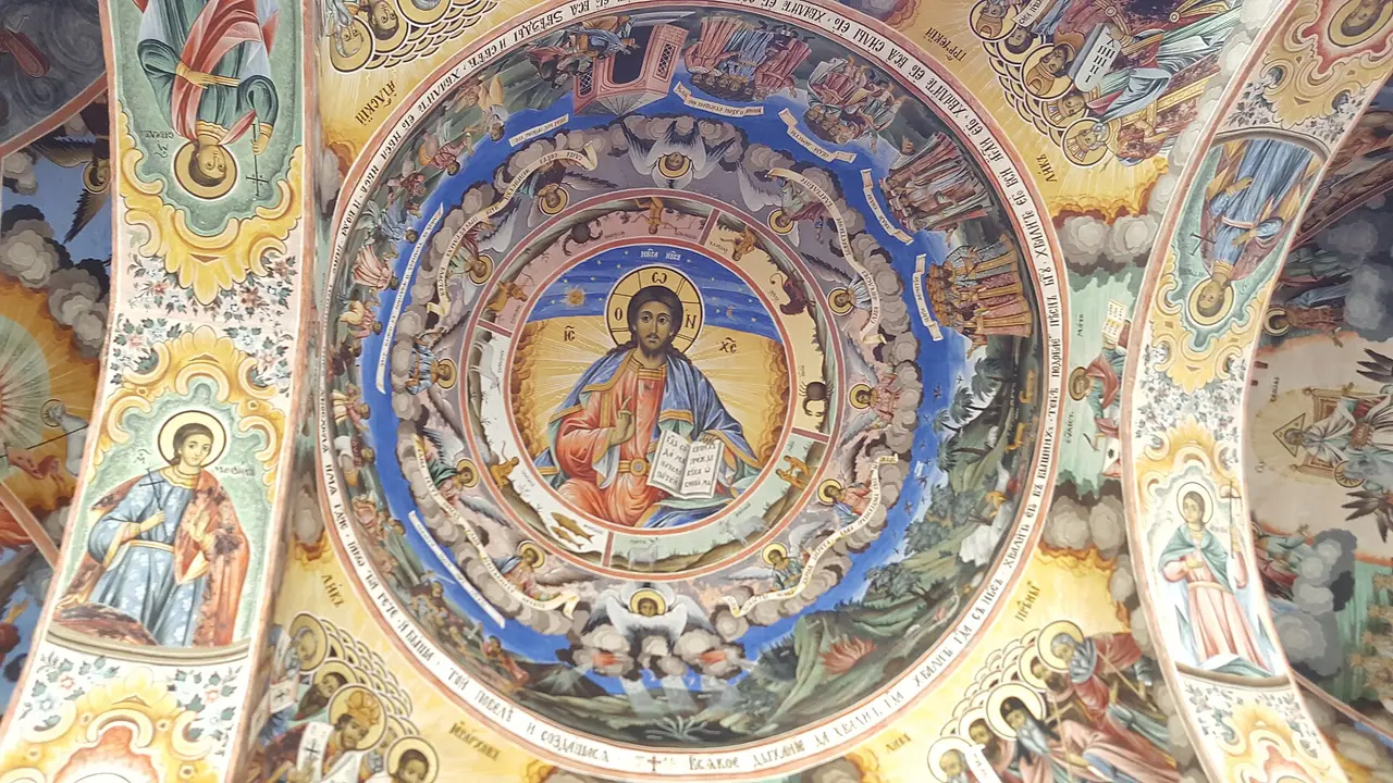 A painted dome inside Rila Monastery church showing Christ Pantocrator ringed by saints and angels