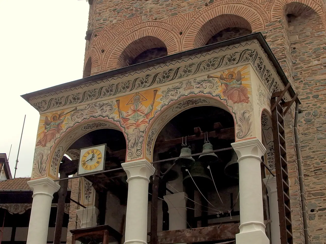 The painted belfry and arches beside the medieval Hrelyo Tower at Rila Monastery, with old bells
