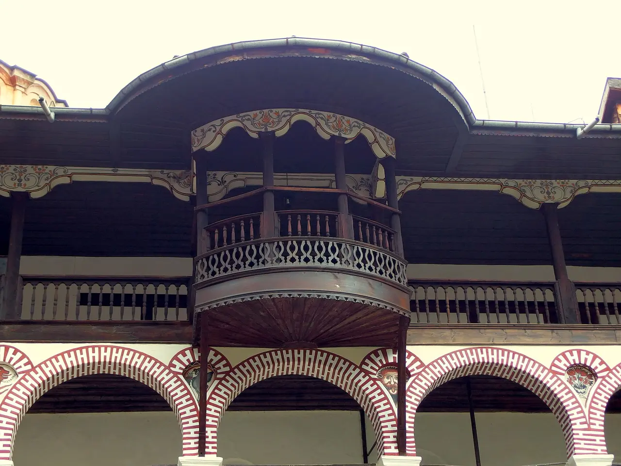 Carved wooden balcony and painted arcaded galleries of the residential wings at Rila Monastery