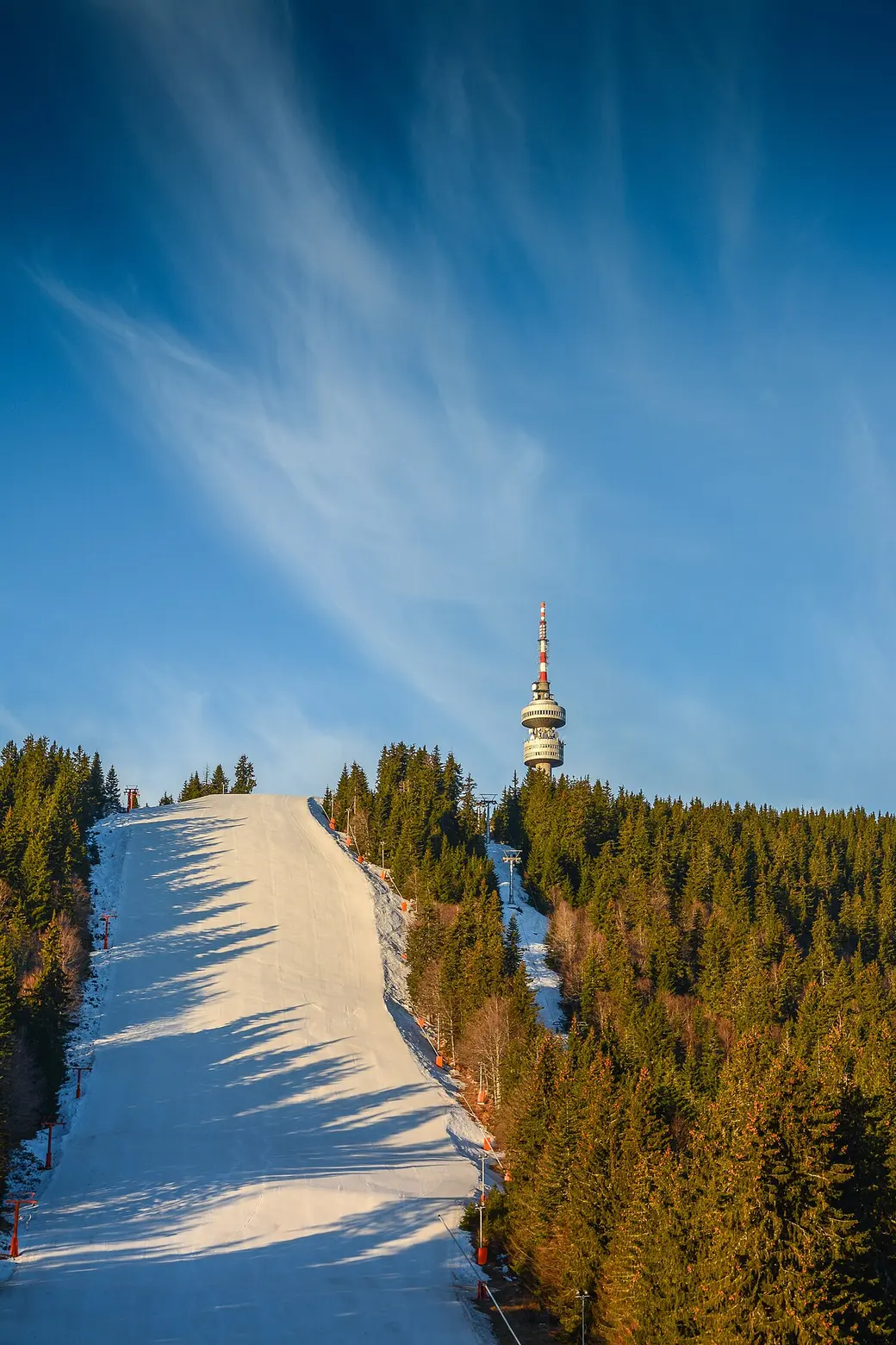 The Snezhanka TV tower on a forested peak above a ski piste at Pamporovo in the Rhodope mountains