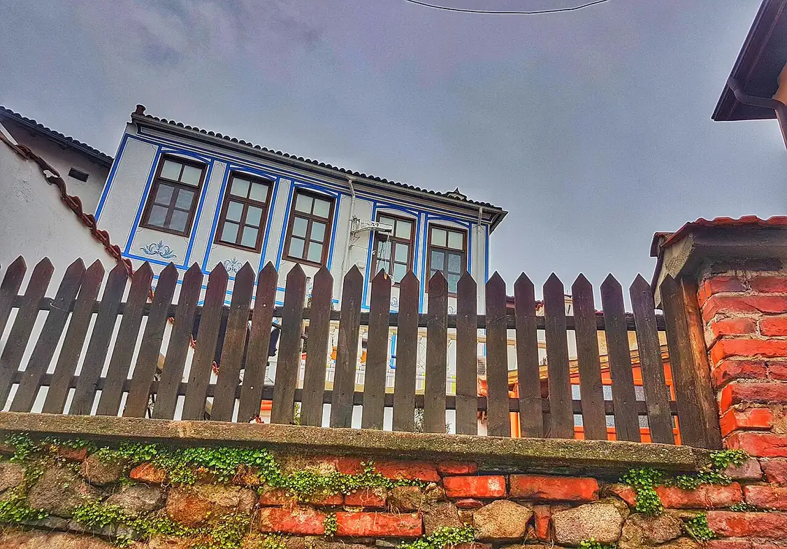 A painted Bulgarian Revival house with blue window frames in the old town of Plovdiv