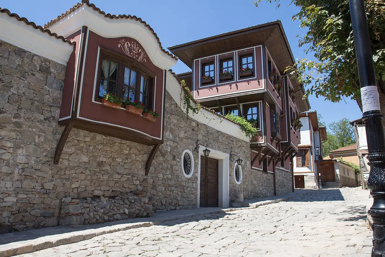A renovated ochre Revival house with ornate windows on a cobbled street in Plovdiv Old Town