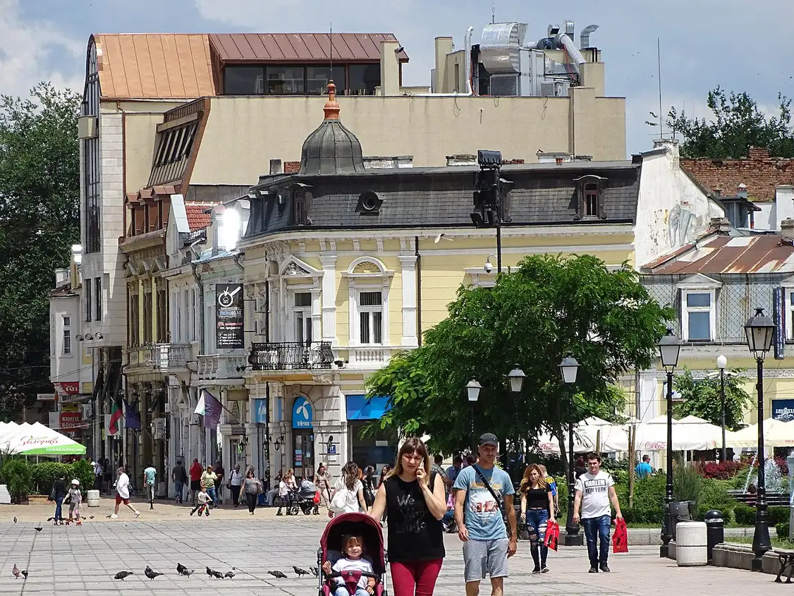The pedestrian Aleksandrovska street in central Ruse with people strolling, cafes, and eclectic 19th-century facades including a yellow neo-Baroque building