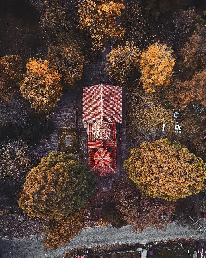 The small stone and brick exterior of the UNESCO-listed Boyana Church surrounded by trees below Vitosha mountain