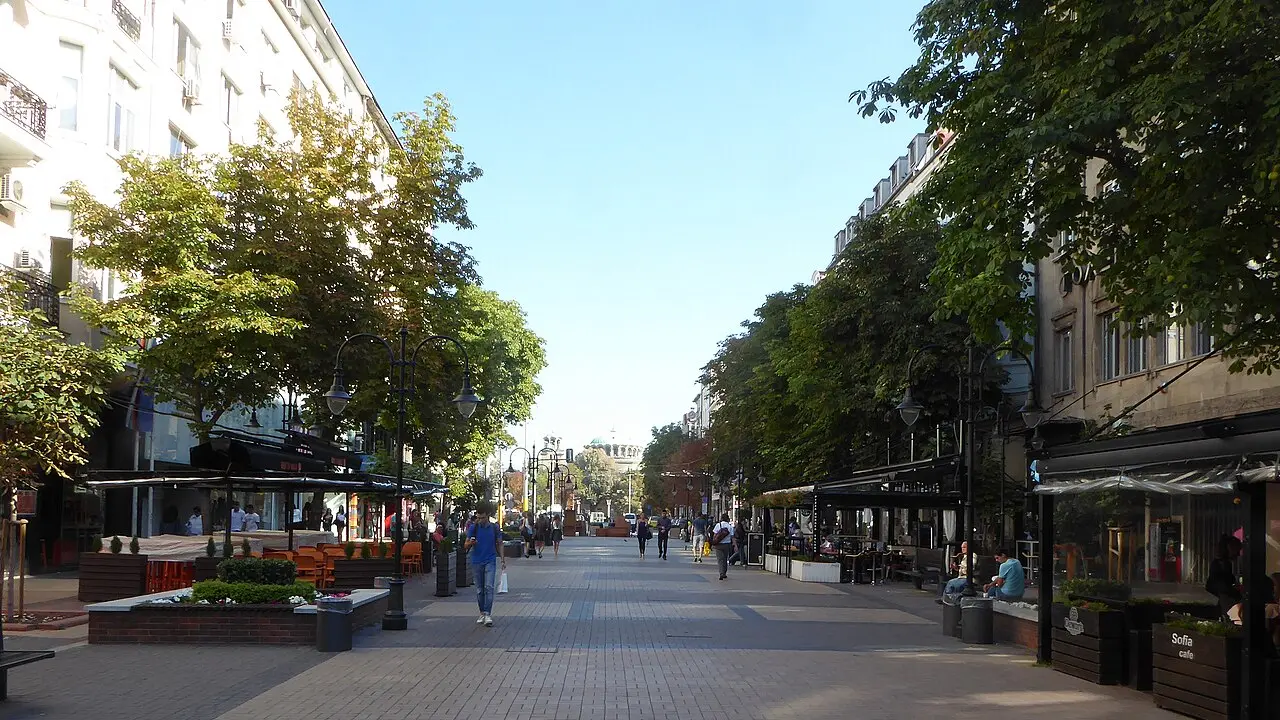 The pedestrianised Vitosha Boulevard in central Sofia on a bright afternoon, with cafe terraces and an ornate corner building
