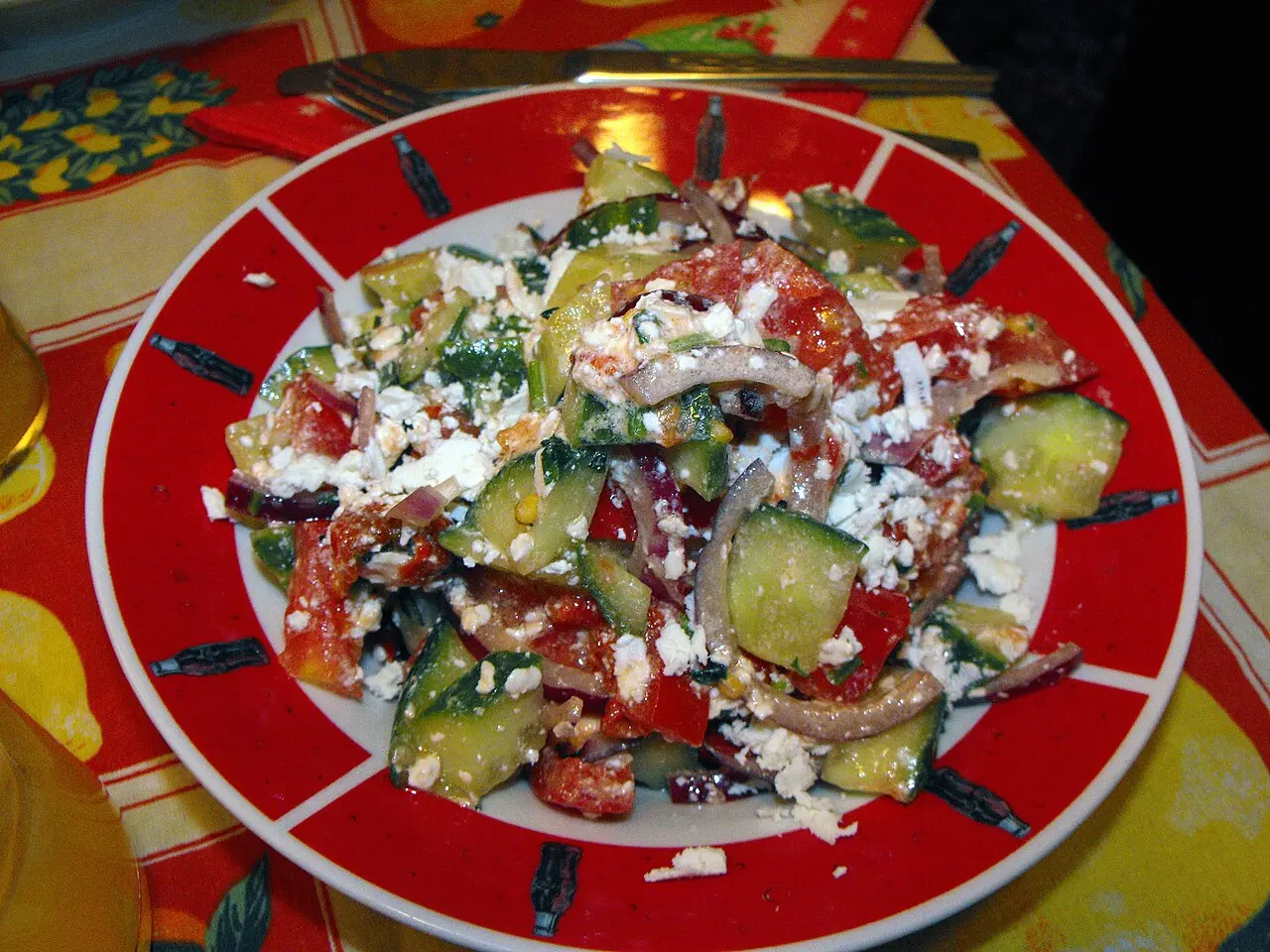 A shopska salad topped with grated white cheese on a restaurant table in Sofia