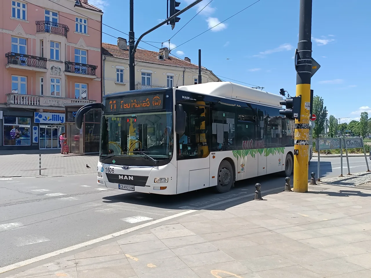 A modern white MAN city bus at a stop on a central Sofia street with older buildings behind