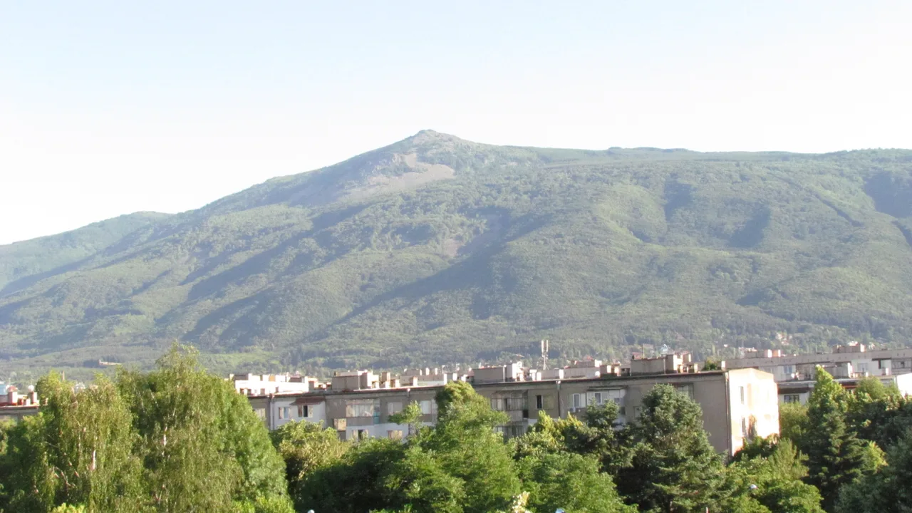 The green wall of Vitosha mountain rising directly above apartment blocks and trees on the southern edge of Sofia