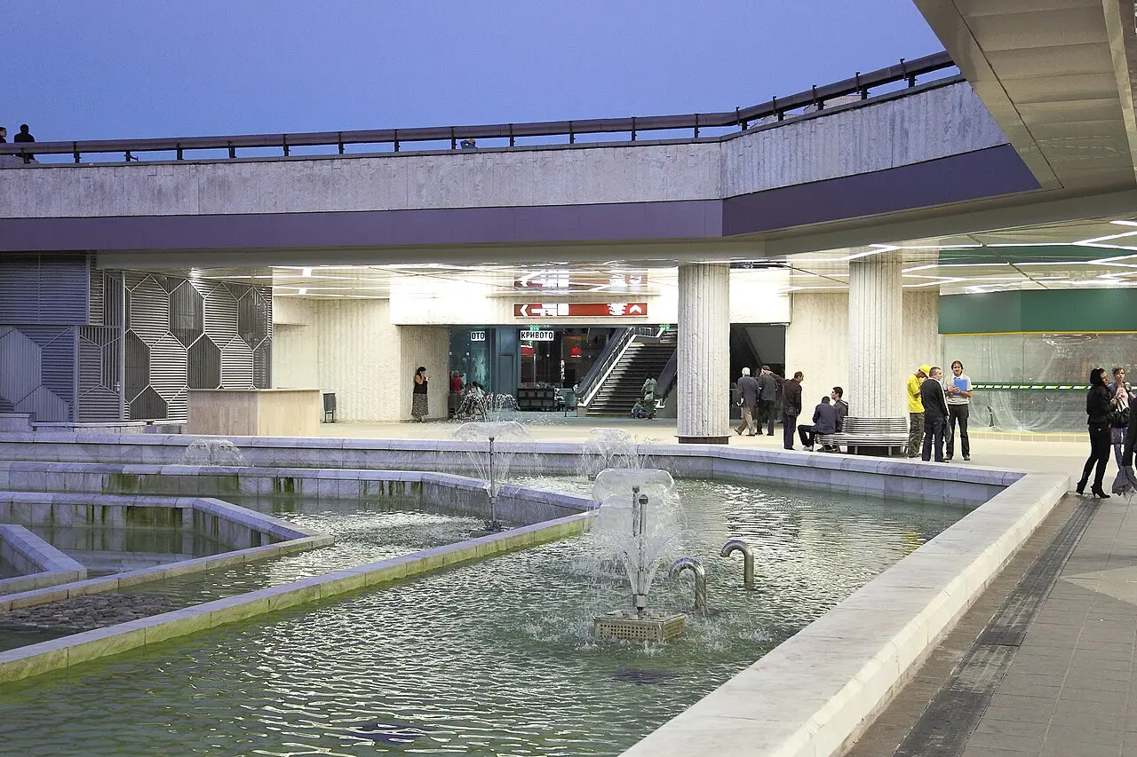 The sunken plaza in front of the National Palace of Culture in Sofia at dusk, with fountains, stone columns and the passage to the metro behind