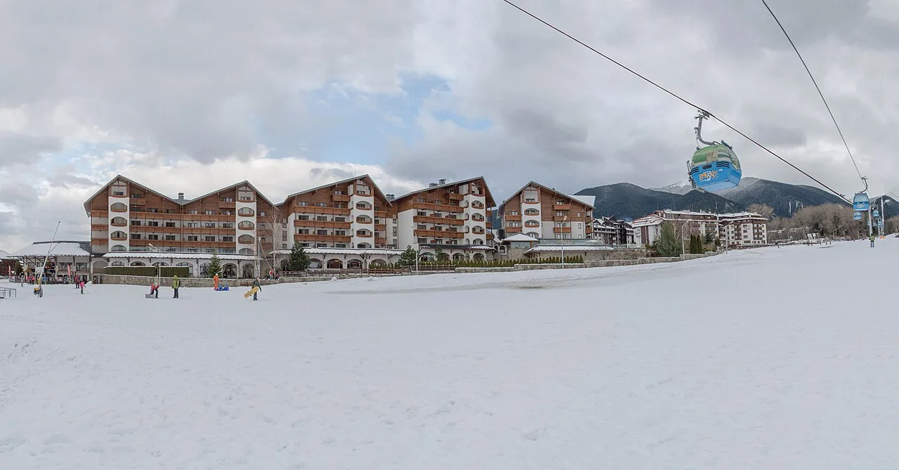 The town of Bansko in winter under snow with the Pirin mountains rising behind it