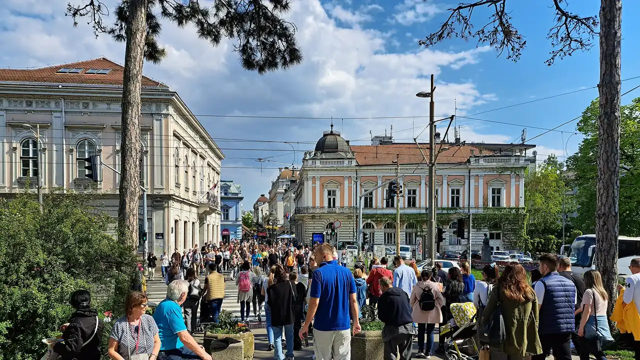 A busy pedestrian street in central Belgrade near the old town with crowds, tram wires and elegant 19th-century buildings