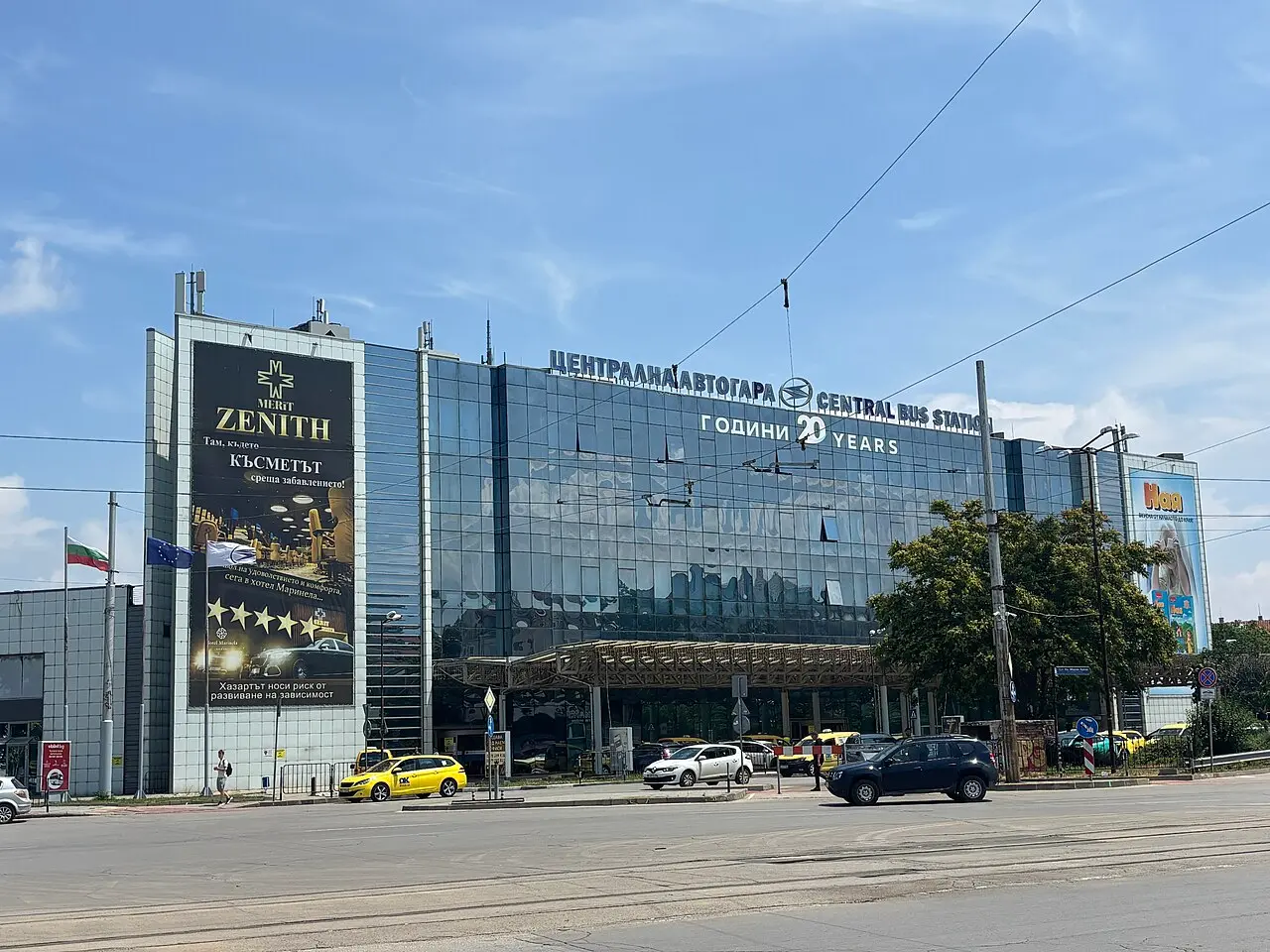 The modern glass front of Sofia Central Bus Station with coaches waiting at the platforms
