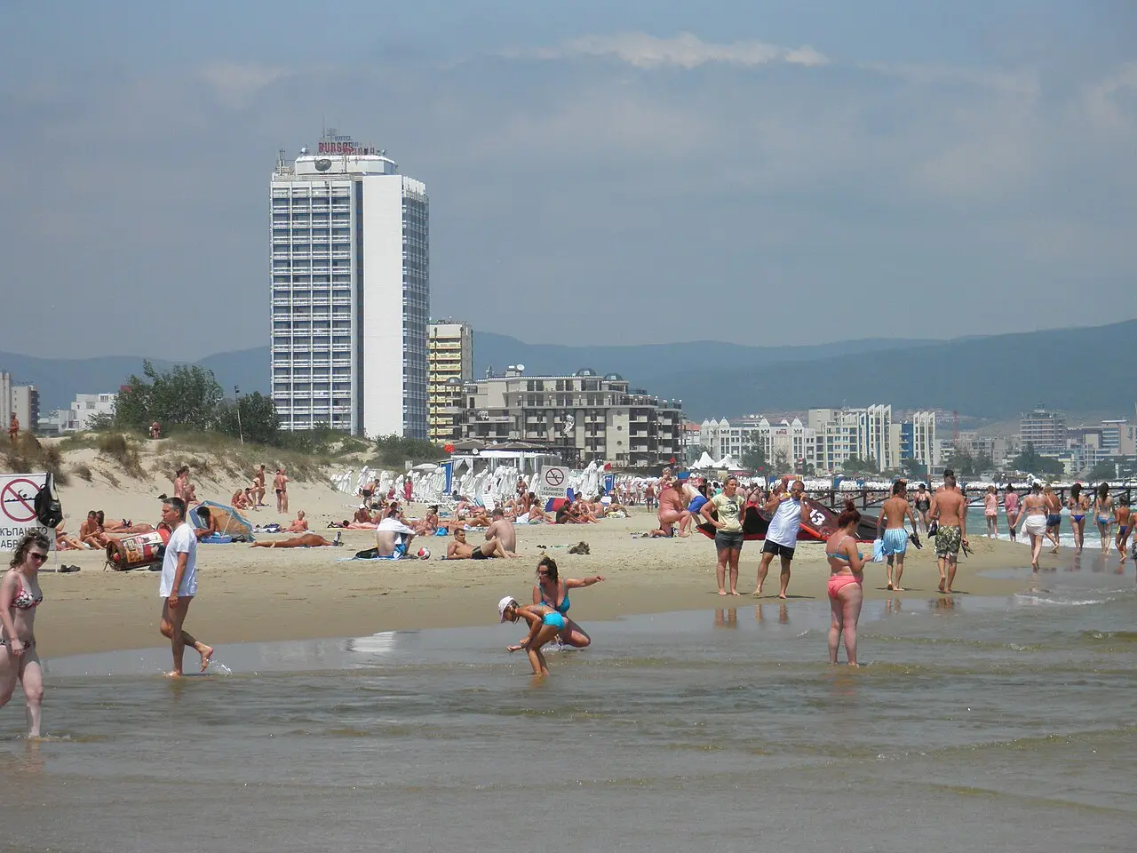 Wide sandy beach and calm Black Sea water at Sunny Beach with sunbeds and umbrellas