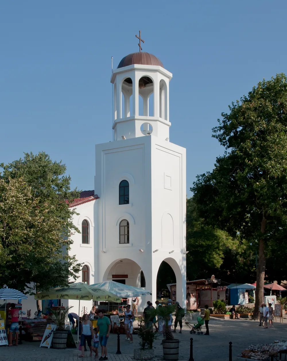 The tall brick bell tower of the Saints Cyril and Methodius church in Sozopol against a blue sky