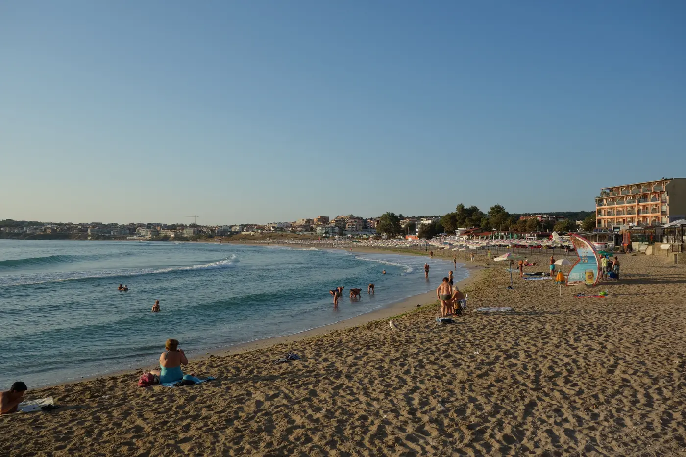 The wide sandy sweep of Harmani beach in the new town of Sozopol with sunbeds and swimmers on a summer day