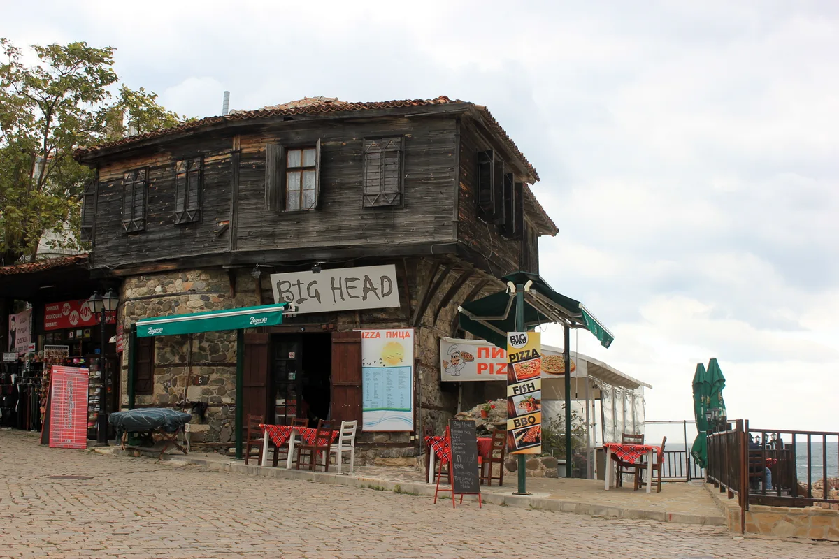 Timber-clad Revival houses in Sozopol old town with overhanging upper floors and a stone-paved street
