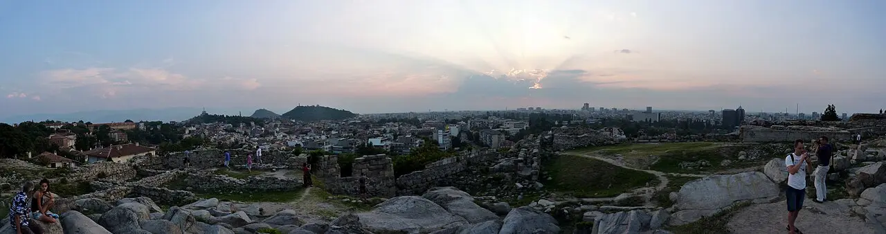 Wide panorama of Plovdiv rooftops and the surrounding plain seen from Nebet Tepe at dusk