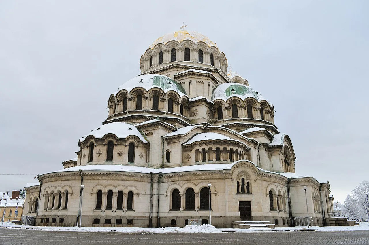 The gold and green domes of the Alexander Nevsky Cathedral in Sofia against a clear sky